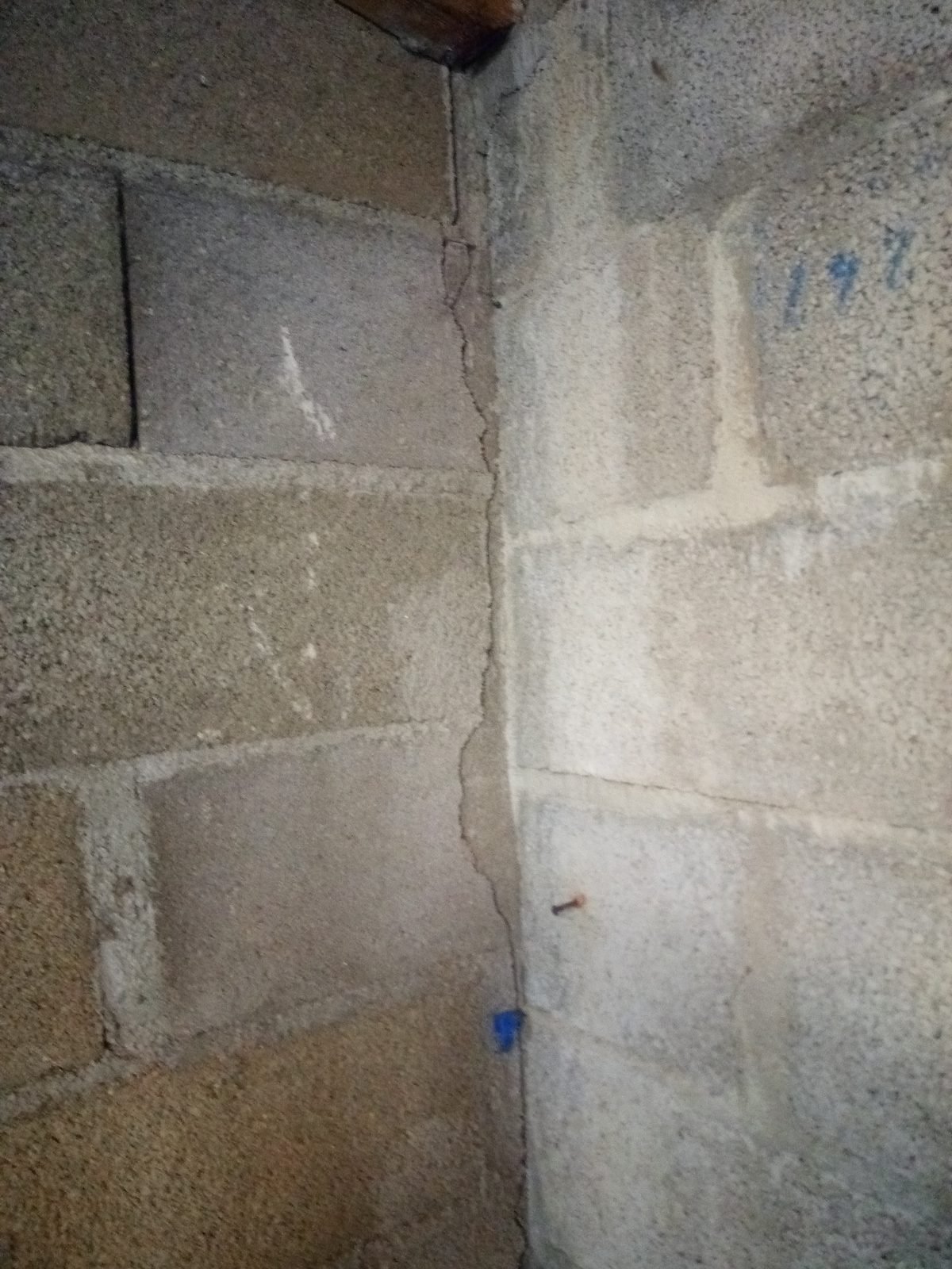 Fissure en escalier sur un mur en parpaings